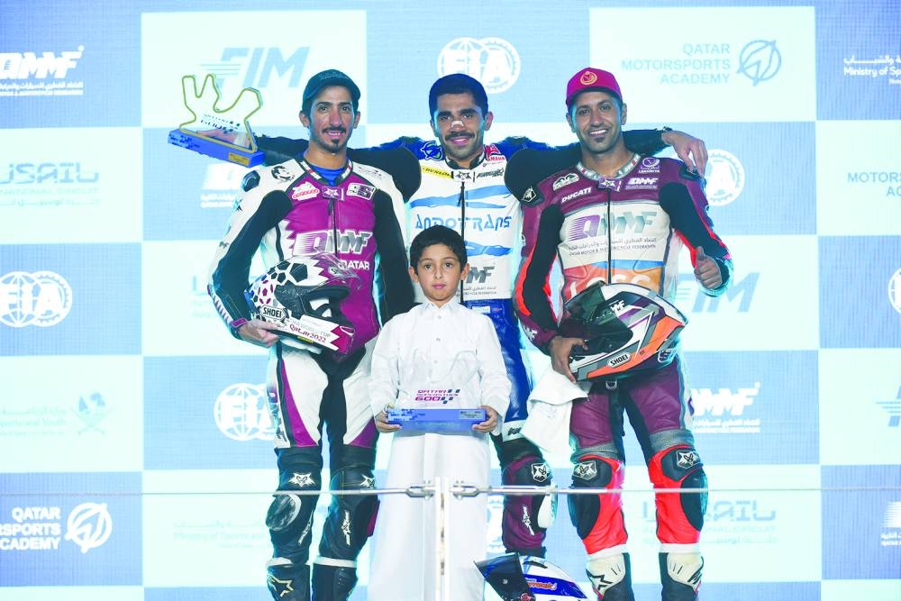 Winner Abdulla al-Qubaisi (centre), second-placed Mashel al-Naimi (left) and third-placed Saeed al-Sulaiti pose on the podium of Qatar Superstock (QSTK) 600 on Sunday.