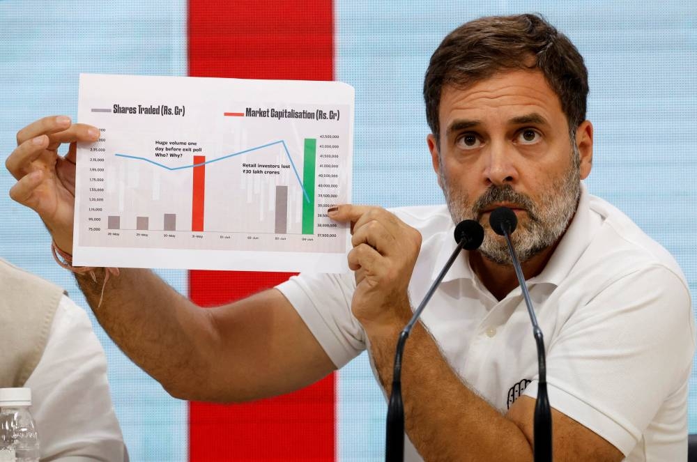 Rahul Gandhi, a senior leader of Congress party, shows a paper as he speaks during a media briefing at the party headquarters in New Delhi, India. 