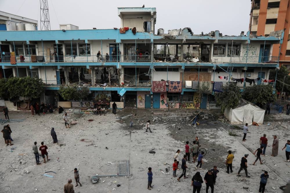 Palestinians inspect the site of an Israeli strike on a UNRWA school sheltering displaced people in Nuseirat refugee camp in the central Gaza Strip, Thursday. REUTERS