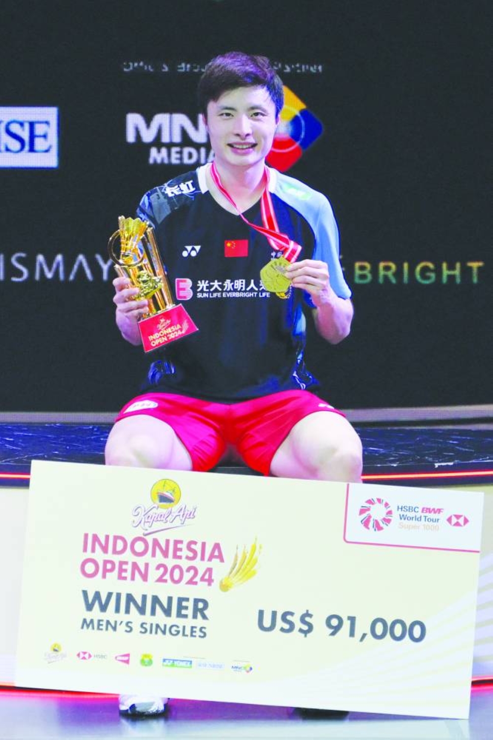 China’s Shi Yuqi poses with his medal and trophy after his victory over Denmark’s Anders Antonsen in their singles final at the Indonesia Open badminton tournament in Jakarta on Sunday. (AFP)