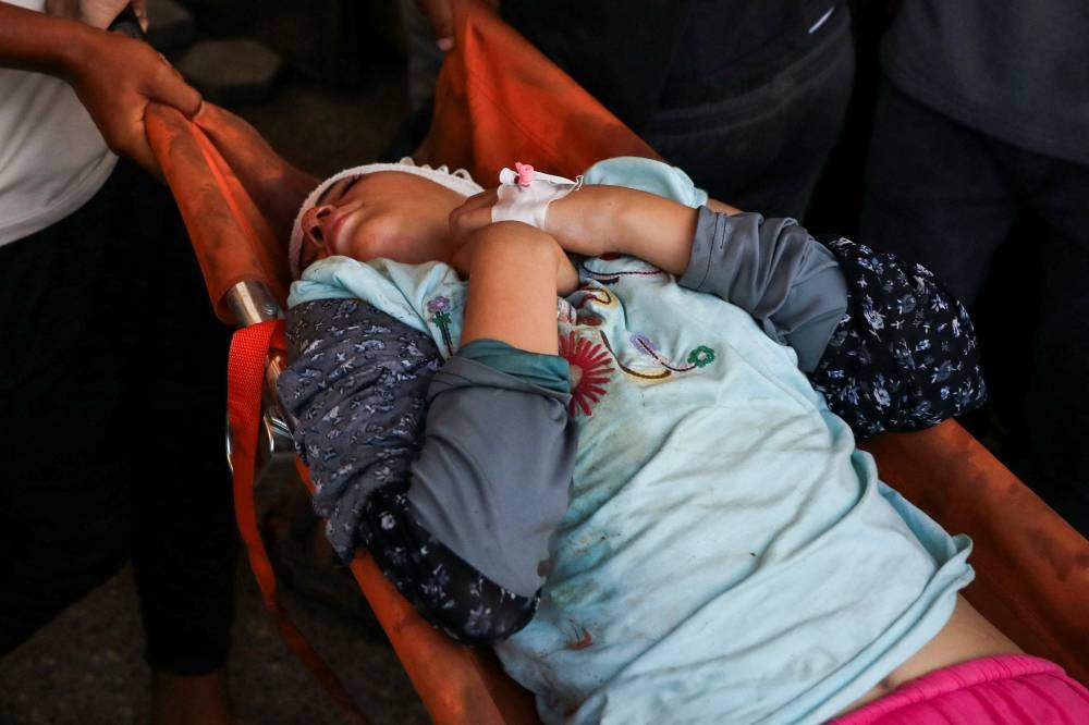 A wounded Palestinian child is carried on stretchers, after an Israeli strike at Al-Aqsa Martyrs Hospital in Deir Al-Balah, in the central Gaza Strip, on Sunday. REUTERS