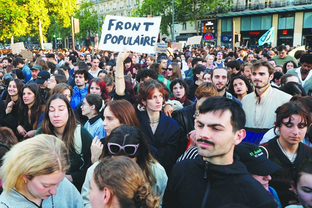 A protester holds a placard reading "Popular Front" during a demonstration at the Place de la Republique against the victory of French far-right party Rassemblement National (RN) in the European elections, in Paris on Monday.