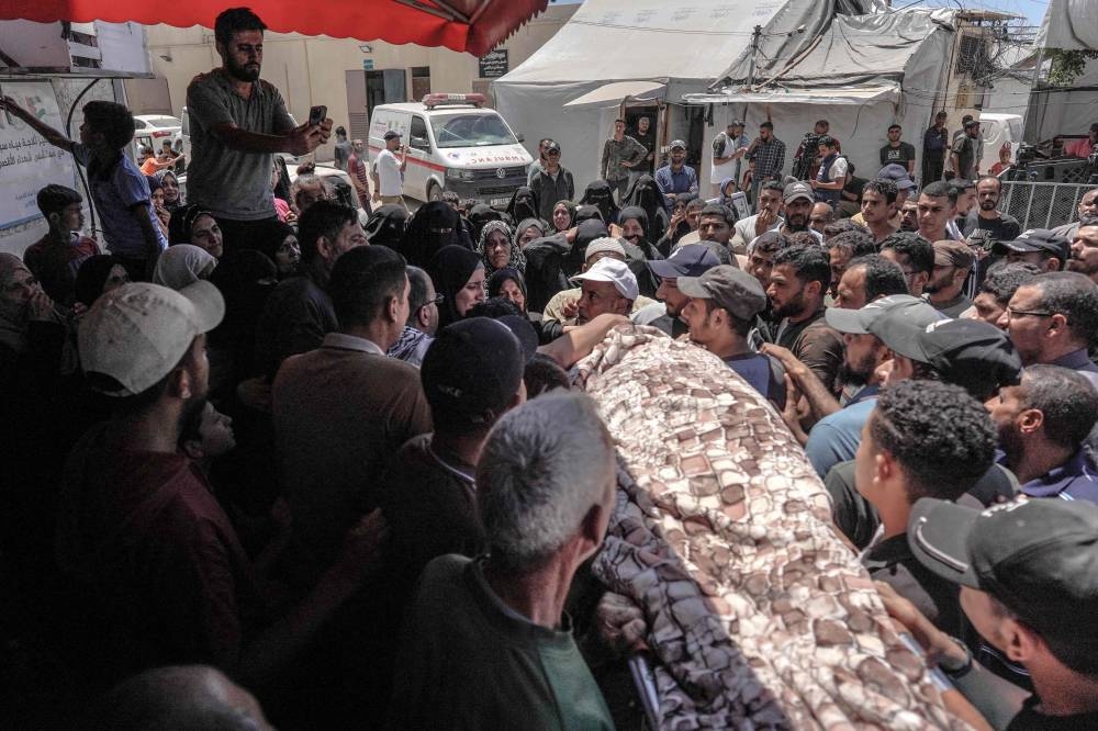 Family members mourn during the funeral of a man who succumbed to his wounds attributed to Israel's bombardment the day before, at  the al-Aqsa Martyrs Hospital in Deir al-Balah, central Gaza Strip on Tuesday. AFP