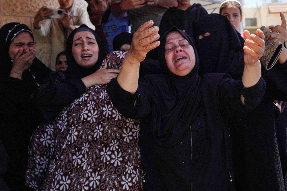 Family members mourn during the funeral of a man who succumbed to his wounds attributed to Israel's bombardment the day before, at  the al-Aqsa Martyrs Hospital in Deir al-Balah, central Gaza Strip on Tuesday. AFP
