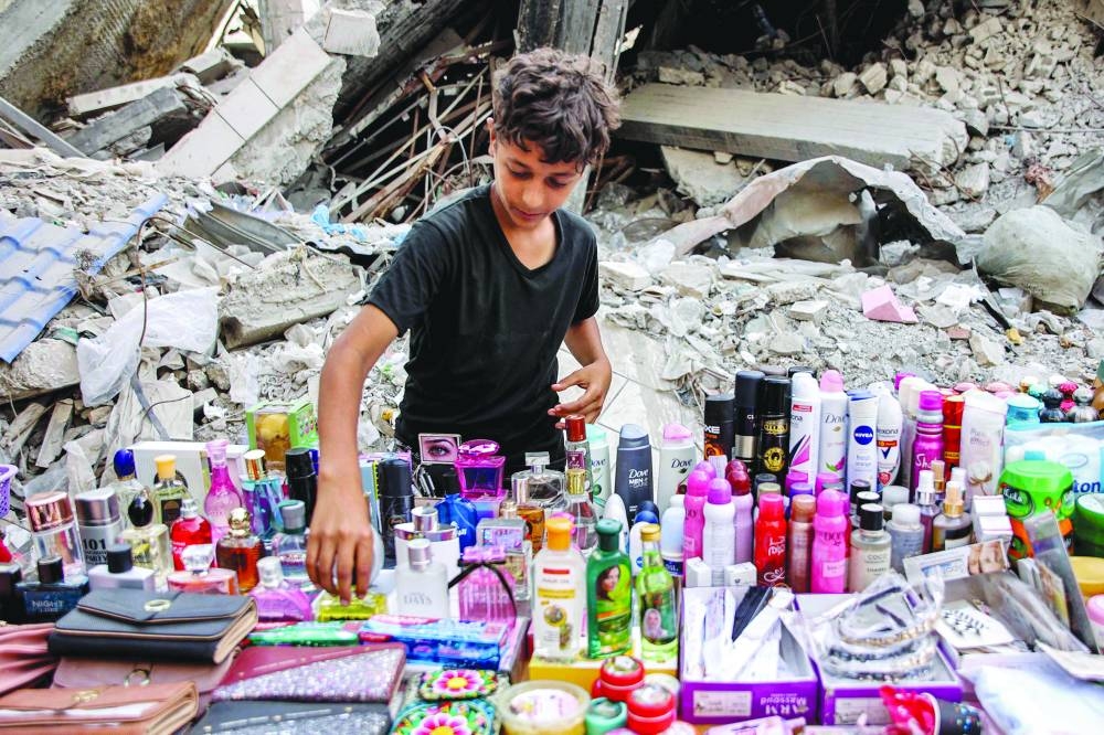 A boy arranges merchandise at a stall at a market in Gaza City Saturday