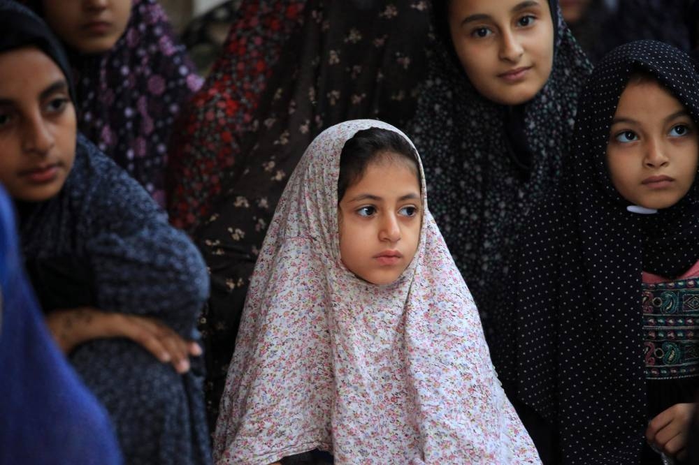 Young Palestinian girls take part in the Eid al-Adha morning prayer in al-Bureij in the central Gaza Strip, on Sunday. AFP