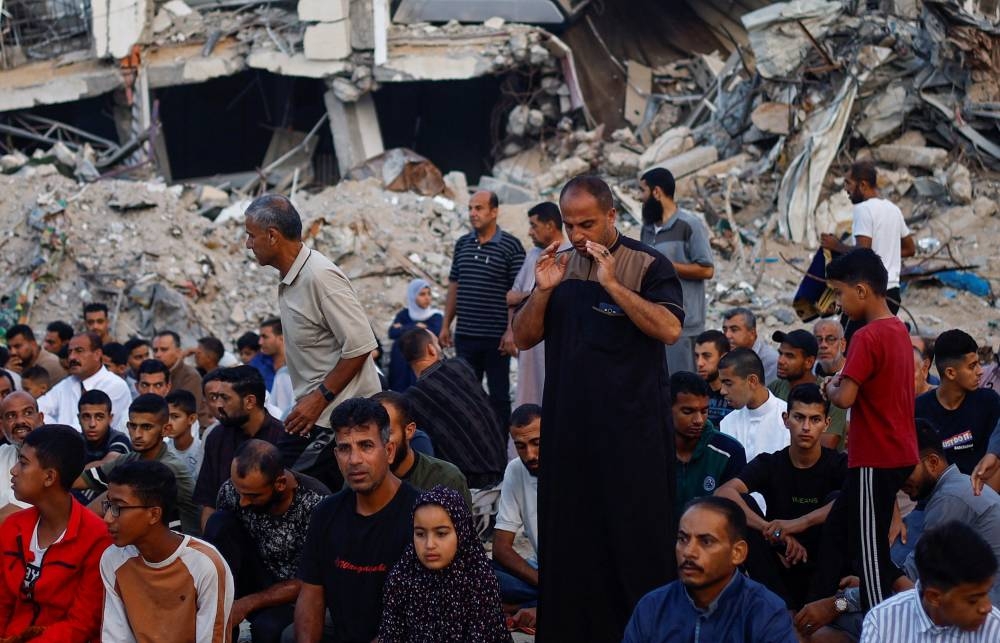 Palestinians hold Eid al-Adha prayers by the ruins of the Al-Rahma mosque destroyed by Israeli air strikes in Khan Younis, in the southern Gaza Strip, on Sunday. REUTERS