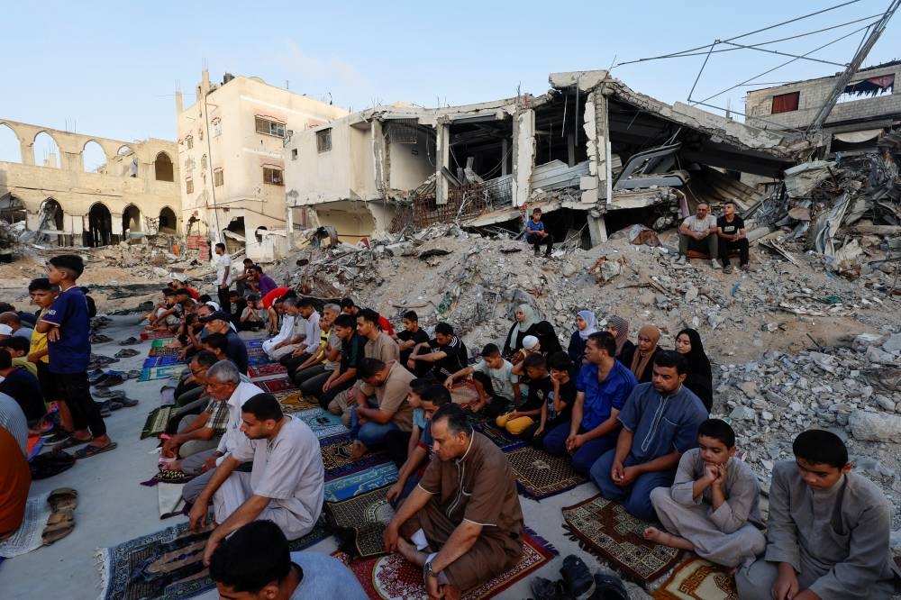 Palestinians hold Eid al-Adha prayers by the ruins of the Al-Rahma mosque destroyed by Israeli air strikes in Khan Younis, in the southern Gaza Strip, on Sunday. REUTERS
