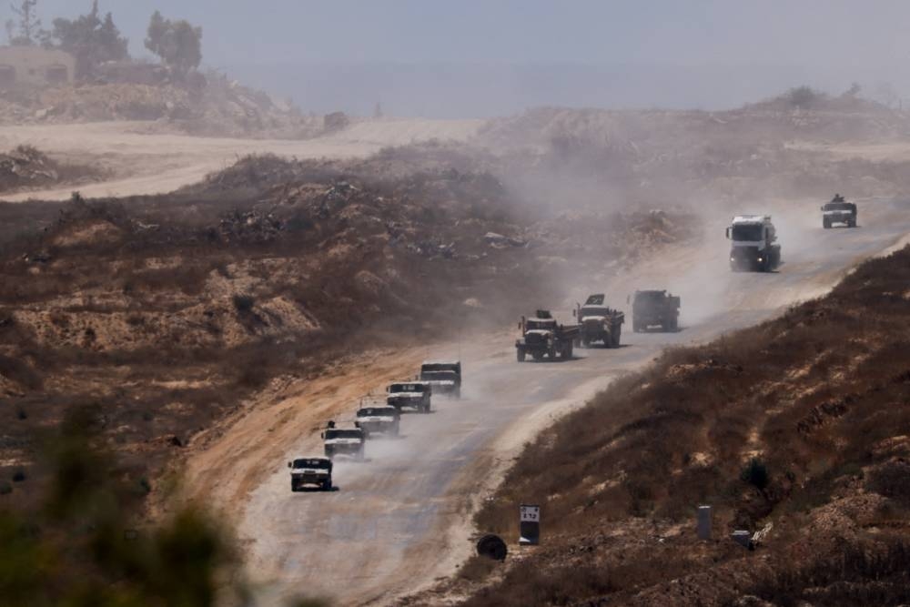 An Israeli military convoy moves inside the Gaza Strip on Monday. REUTERS