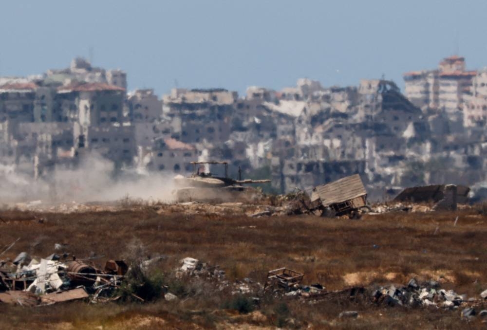 An Israeli tank manoeuvres inside the Gaza Strip as seen from Israel, on Monday. REUTERS