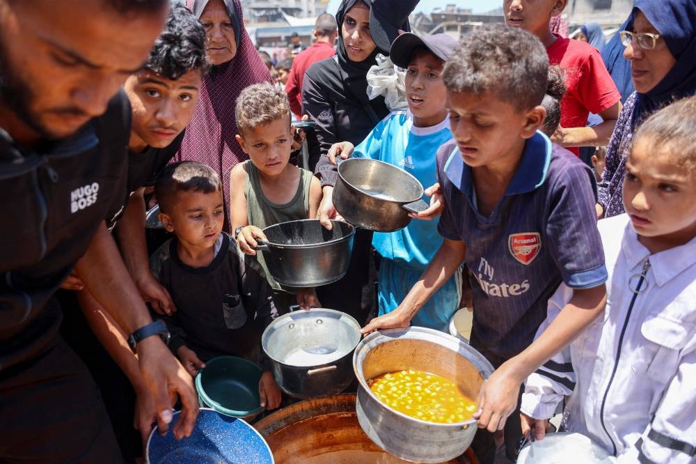 Children line up to receive food at a UN Relief and Works Agency for Palestine Refugees (UNRWA) school in the Jabalia camp for Palestinian refugees in the northern Gaza Strip on Monday. AFP