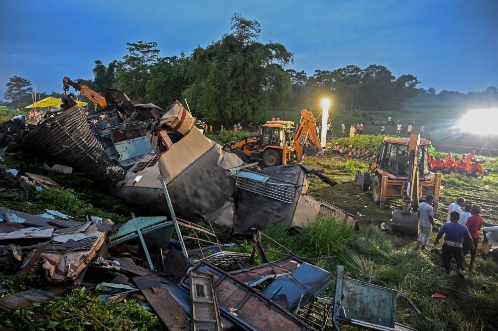 Railway workers help to restore services at the accident site following a collision between a passenger and a goods train in Nirmaljote, near Rangapani station in India's West Bengal state on June 17, 2024. At least eight people were killed in India on June 17 when a goods train driver missed a signal and slammed into an express passenger train from behind, police and railway officials said. (Photo by DIBYANGSHU SARKAR / AFP)