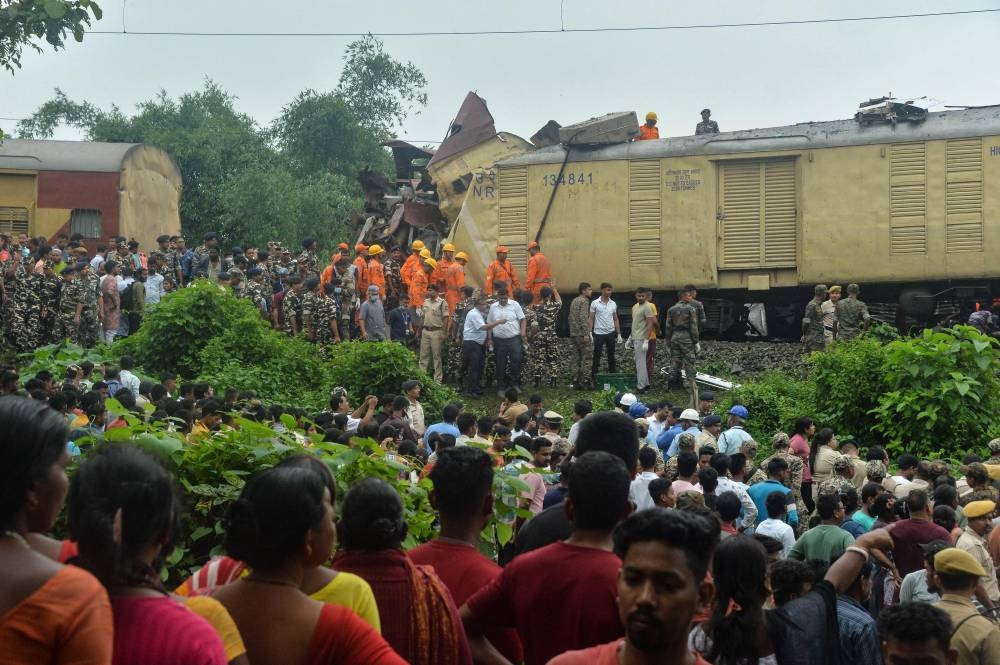 National Disaster Response Force (NDRF) and security personnel gather at the site of a collision between an passenger and a goods train in Nirmaljote, near Rangapani station in India's West Bengal state on Monday. AFP