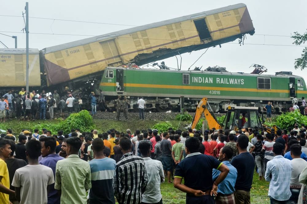 People gather near the site of a collision between an passenger and a goods train in Nirmaljote, near Rangapani station in India's West Bengal state on Monday. AFP