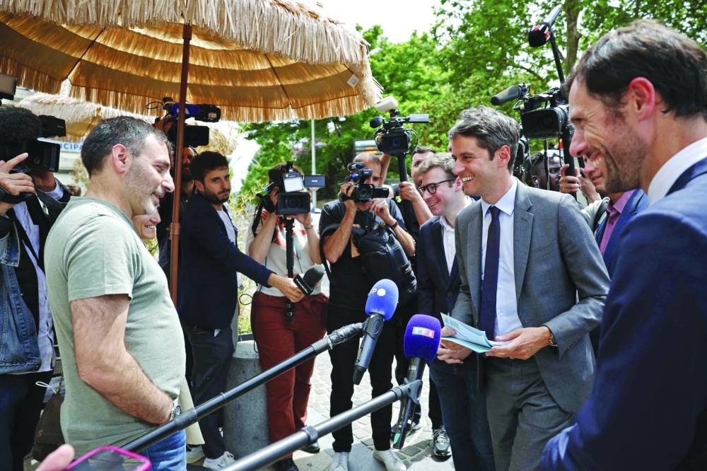 France's Prime Minister Gabriel Attal (2ndR) and French MP for the Renaissance group Mathieu Lefevre (R), candidate for his re-election in the 5th constituency of the Val-de-Marne department, meet with local residents in Le Perreux-sur-Marne, east of Paris, Monday.