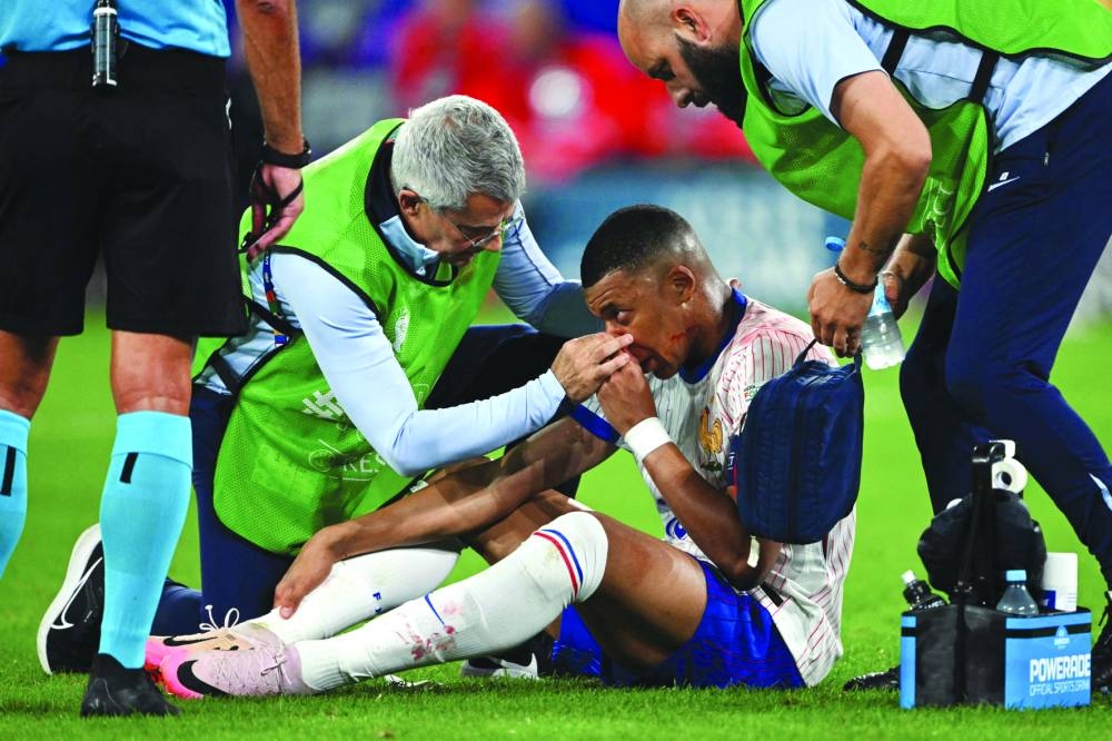 France’s forward Kylian Mbappe receives medical treatment during the UEFA Euro 2024 Group D match against Austria at the Duesseldorf Arena in Duesseldorf on Monday. (AFP)