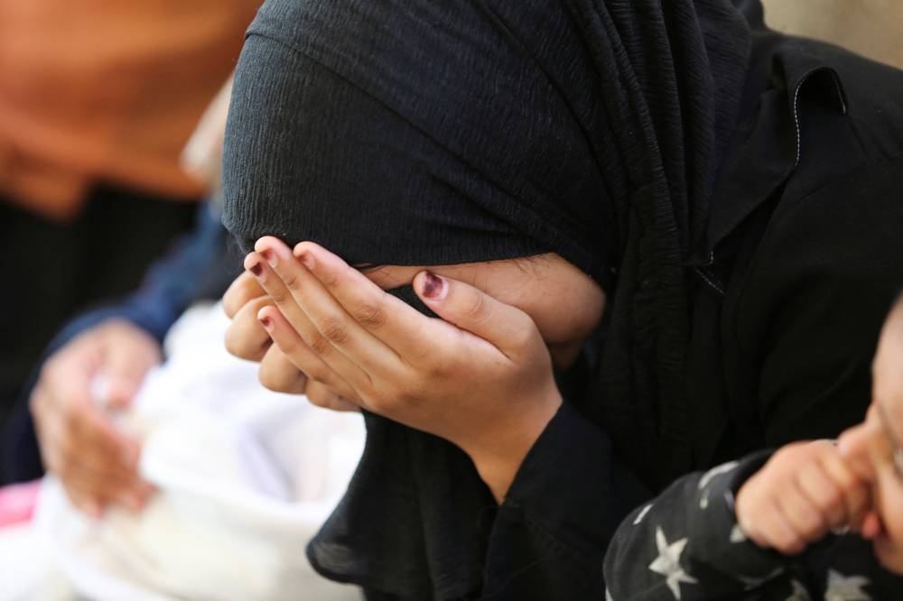 A mourner reacts next to the bodies of Palestinians, killed in Israeli strikes due to a military operation in Rafah on Tuesday. REUTERS