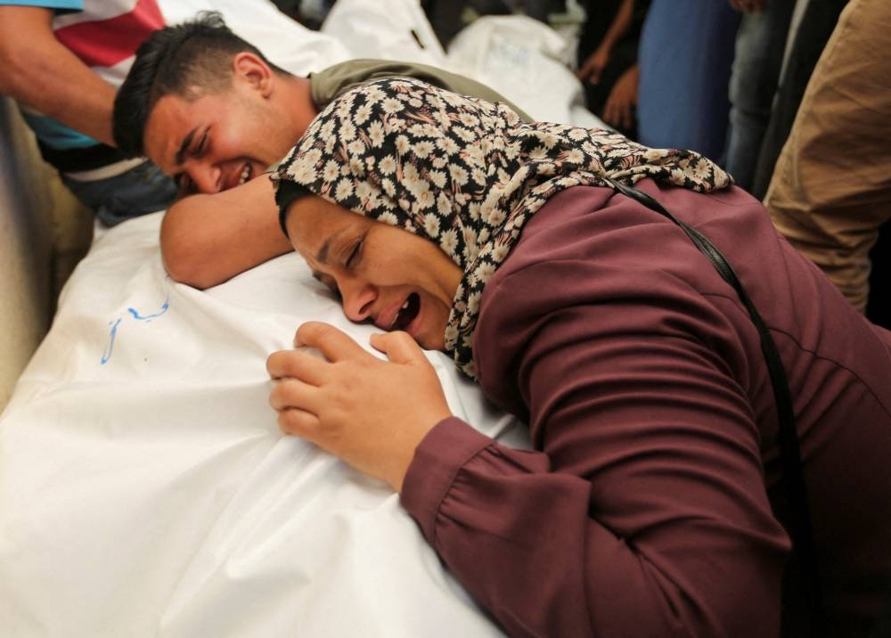 Mourners react next to the bodies of Palestinians, killed in Israeli strikes due to a military operation in Rafah, on Tuesday. REUTERS