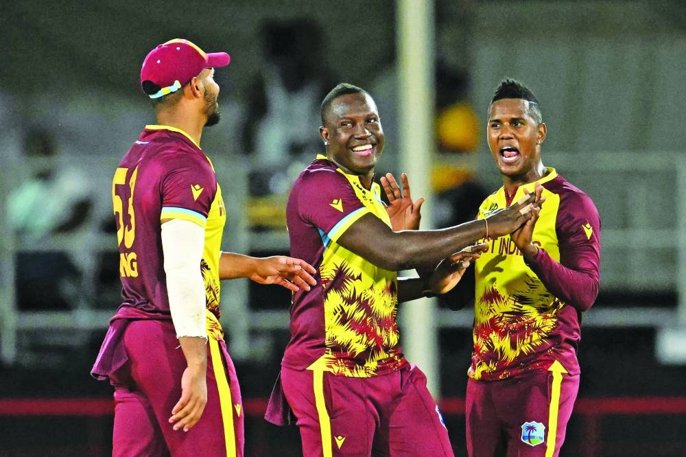 West Indies' Akeal Hosein (right) celebrates after dismissing Afghanistan's Azmatullah Omarzai (out of frame) with teammates West Indies' Brandon King (left) and captain Rovman Powell (centre) during the ICC Twenty20 World Cup match at Daren Sammy Cricket Ground in Gros Islet, St. Lucia, on Tuesday. (AFP)