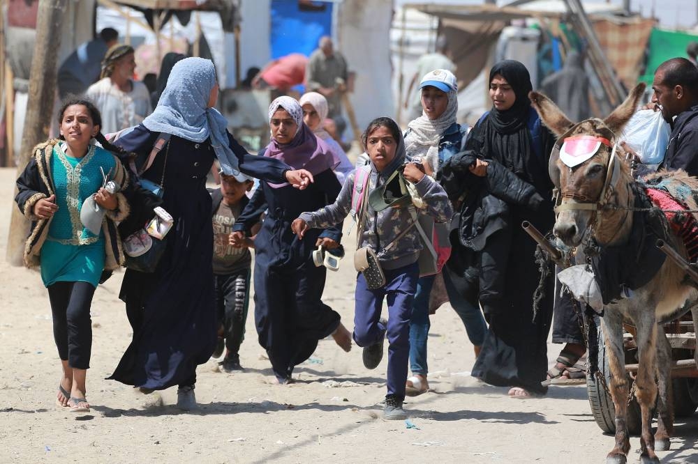 Palestinians rush during Israeli bombardment in the area in Rafah in the southern Gaza Strip Wednesday. AFP