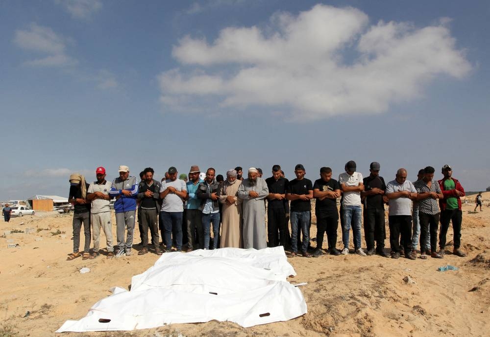 Mourners pray next to the bodies of Palestinians killed in Israeli strikes in Rafah, in Khan Younis, in the southern Gaza Strip, on Wednesday. REUTERS
