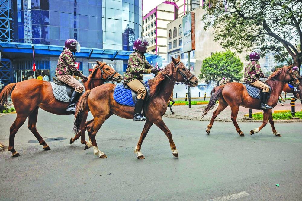 
Kenya mounted police officers patrol on horses during a demonstration against tax hikes. 