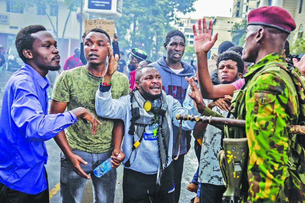 
Protesters react while talking to a Kenya police officer in downtown Nairobi. 