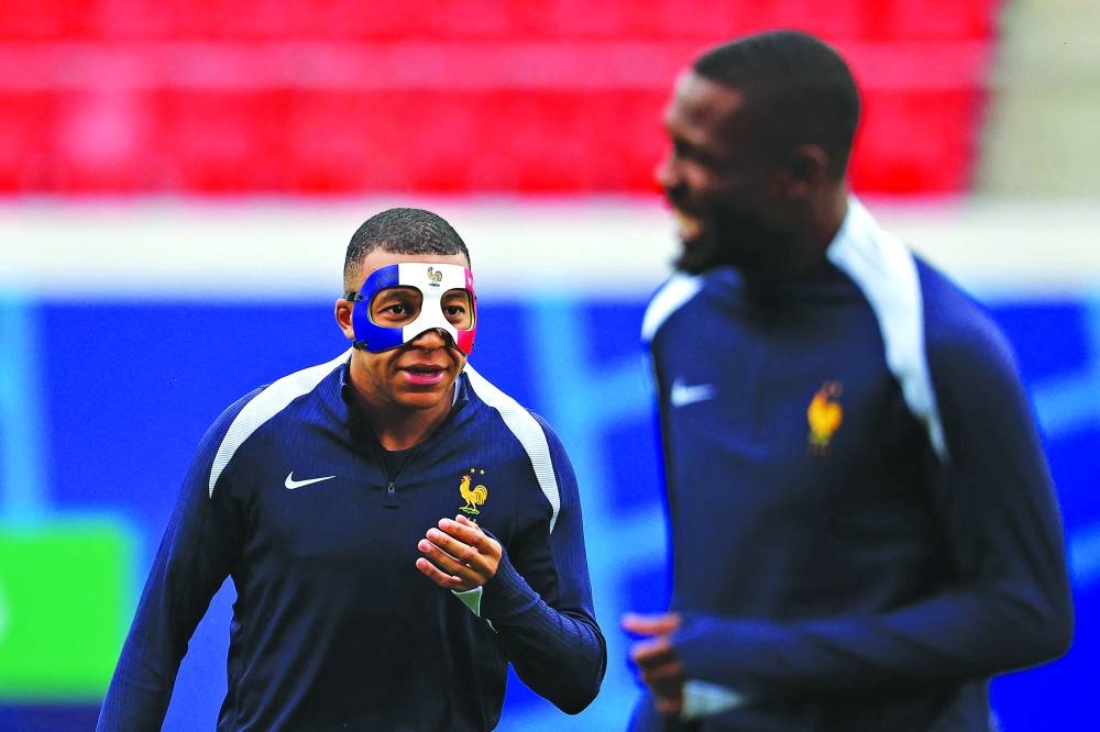 France’s forward Kylian Mbappe arrives wearing a face mask to take part in a training session in Leipzig on Thursday, on the eve of their Euro 2024 Group D match against Netherlands. (AFP)