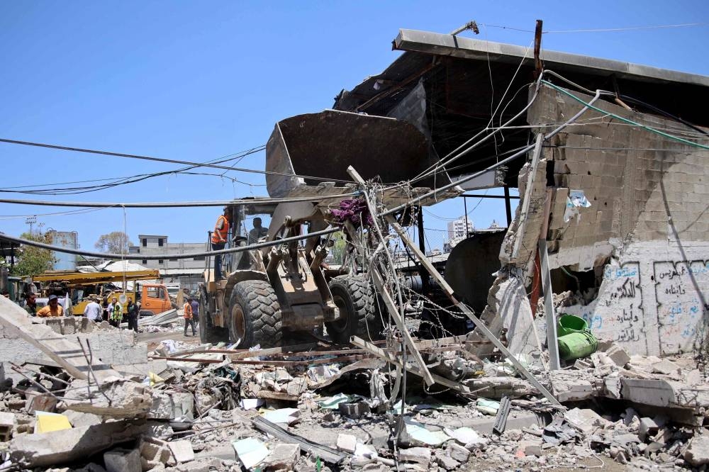 A digger is used to clear the debris following the Israeli military bombardment of the Gaza Municipality garage on al-Wahda Street, in the al-Daraj neighborhood in Gaza City on, on Friday. AFP