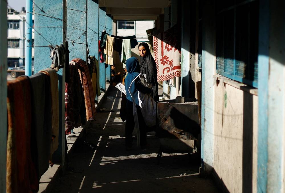 A Palestinian woman looks on as she stands in a UNRWA school, after the air strike on a neighbouring house to the school in Khan Younis, in the southern Gaza Strip, on Friday. REUTERS