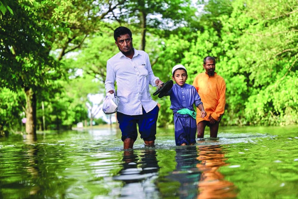 People wade through flood waters following heavy rainfall in Sylhet, Bangladesh, on Friday.