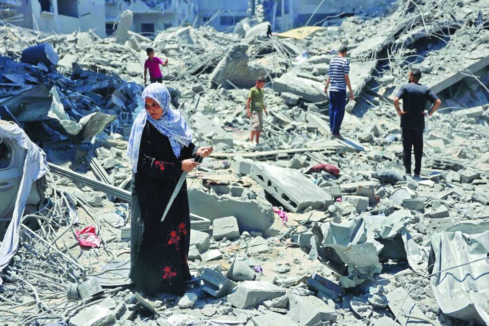 A woman looks for salvageable items following Israeli bombardment at Al-Shati refugee camp in Gaza City, yesterday, amid the ongoing conflict between Israel and Hamas.