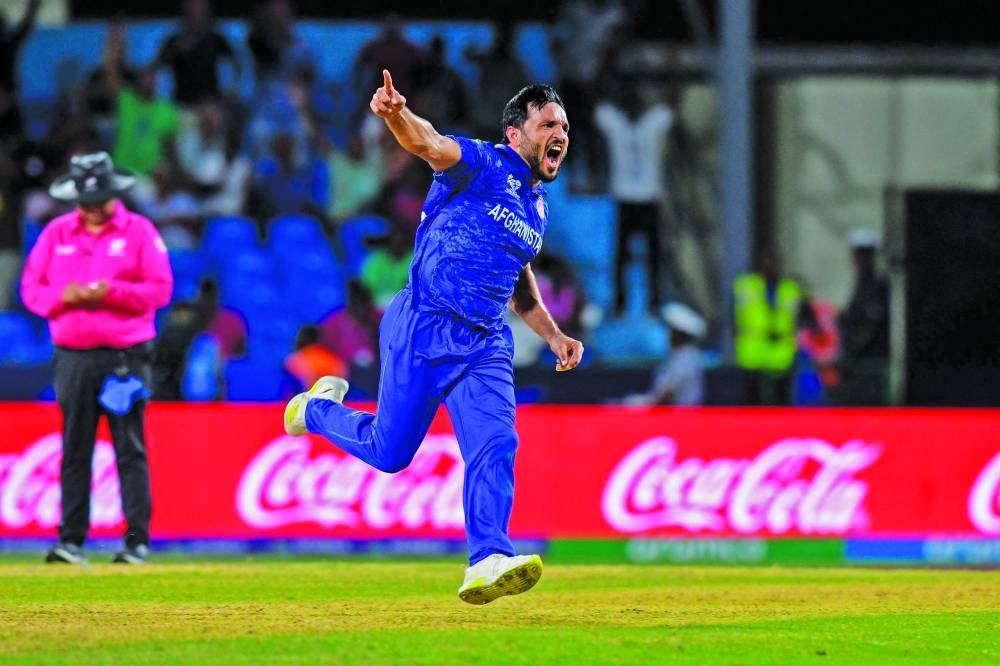
Afghanistan’s Gulbadin Naib celebrates after the dismissal of Australia’s Pat Cummins during the ICC Twenty20 World Cup Super Eight match at Arnos Vale Stadium in Arnos Vale, Saint Vincent and the Grenadines yesterday. Right: Afghanistan’s Nangyal Kharoti (left), Naveen-ul-Haq (centre) and Rahmanullah Gurbaz celebrate after the dismissal of Ashton Agar. (AFP) 