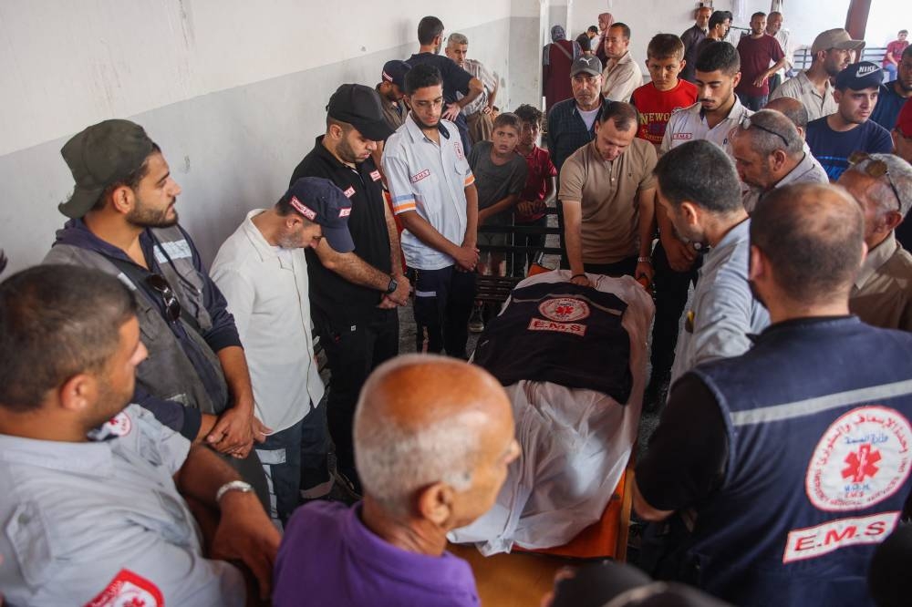 Relatives and medics mourn by the body of Palestinian doctor Hani al-Jaafarawi, Gaza’s ambulance and emergency teams chief during his funeral at Al-Ahli Arab hospital, also known as the Baptist hospital on Monday, a day after he was killed in an overnight Israeli strike on al-Daraj clinic in Gaza City. AFP