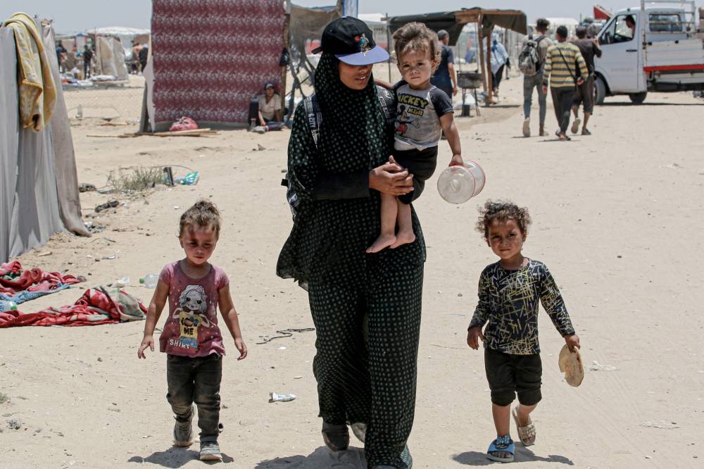 Displaced Palestinians evacuate the Mawassi area on the outskirts of in southwestern Khan Yunis in the southern Gaza Strip on Friday. AFP