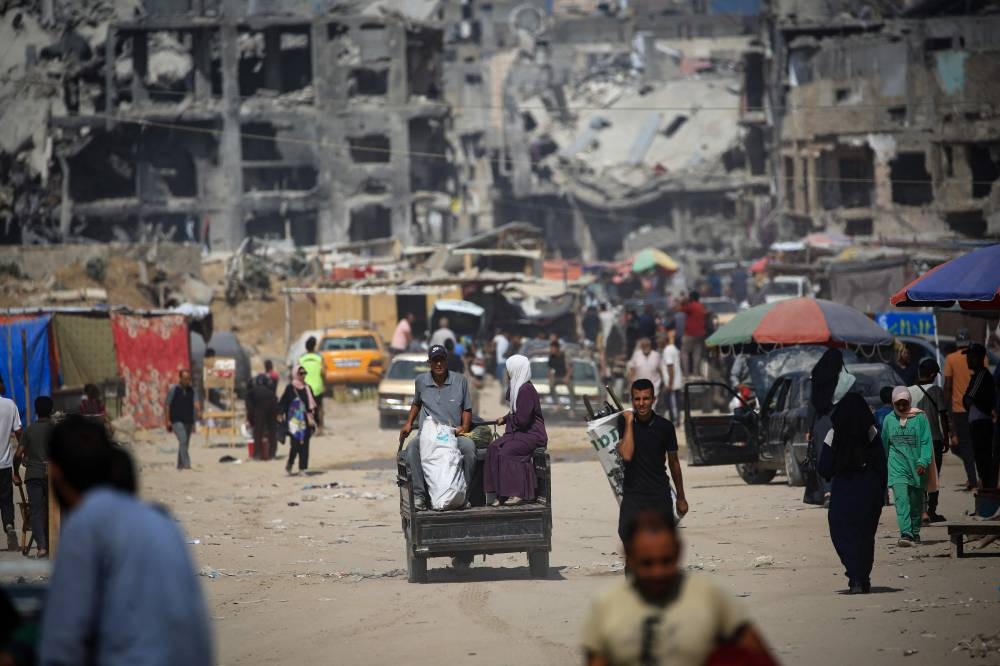 Palestinian walks down a street past destroyed buildings as some residents return to the city of Khan Yunis, in the southern Gaza Strip on Sunday. AFP