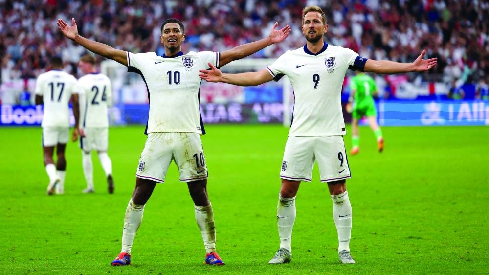 England's midfielder #10 Jude Bellingham celebrates with England's forward #09 Harry Kane after scoring his team's first goal during the UEFA Euro 2024 round of 16 football match between England and Slovakia at the Arena AufSchalke in Gelsenkirchen on June 30, 2024. (Photo by Adrian DENNIS / AFP)