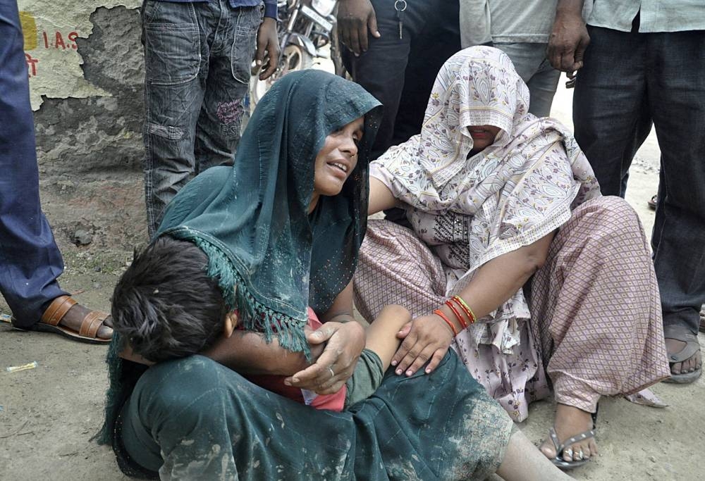  A woman is consoled as she mourns after her son died in a stampede outside a hospital in Hathras, Tuesday. REUTERS