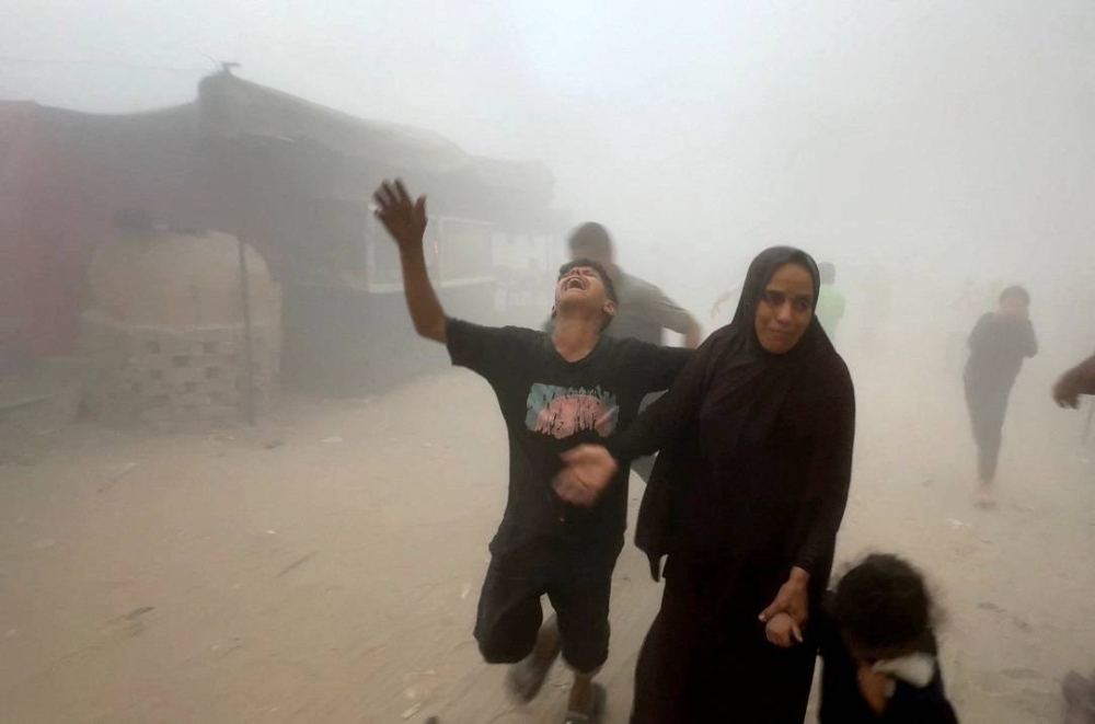 Palestinians react following an Israeli strike near a UN-run school sheltering displaced people, in Khan Younis in the southern Gaza Strip Wednesday. REUTERS
