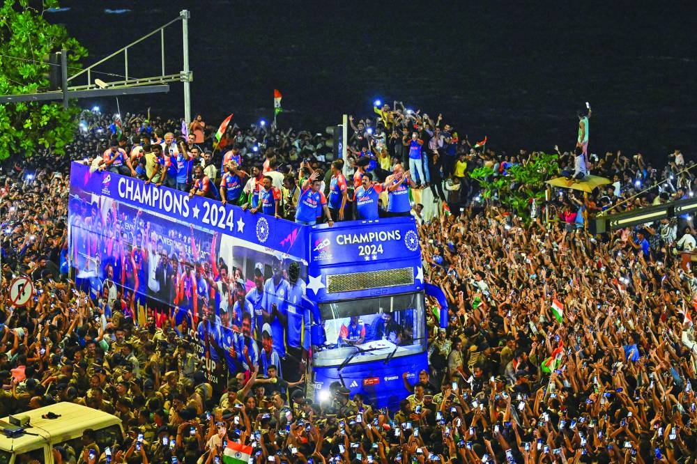 Indian players gesture during an open bus roadshow upon their arrival in Mumbai on Thursday, after winning the ICC Twenty20 World Cup in Barbados last Saturday. (AFP)