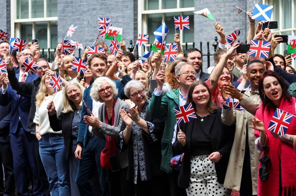 Supporters greet British Prime Minister Keir Starmer and his wife Victoria Starmer, at Downing Street, following the results of the election, in London, Friday. REUTERS