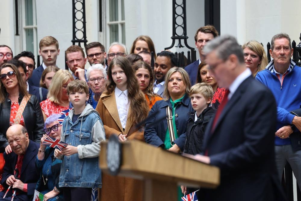 Guests watch as British Prime Minister Keir Starmer delivers his speech outside Number 10 Downing Street, election, in London, Friday. REUTERS