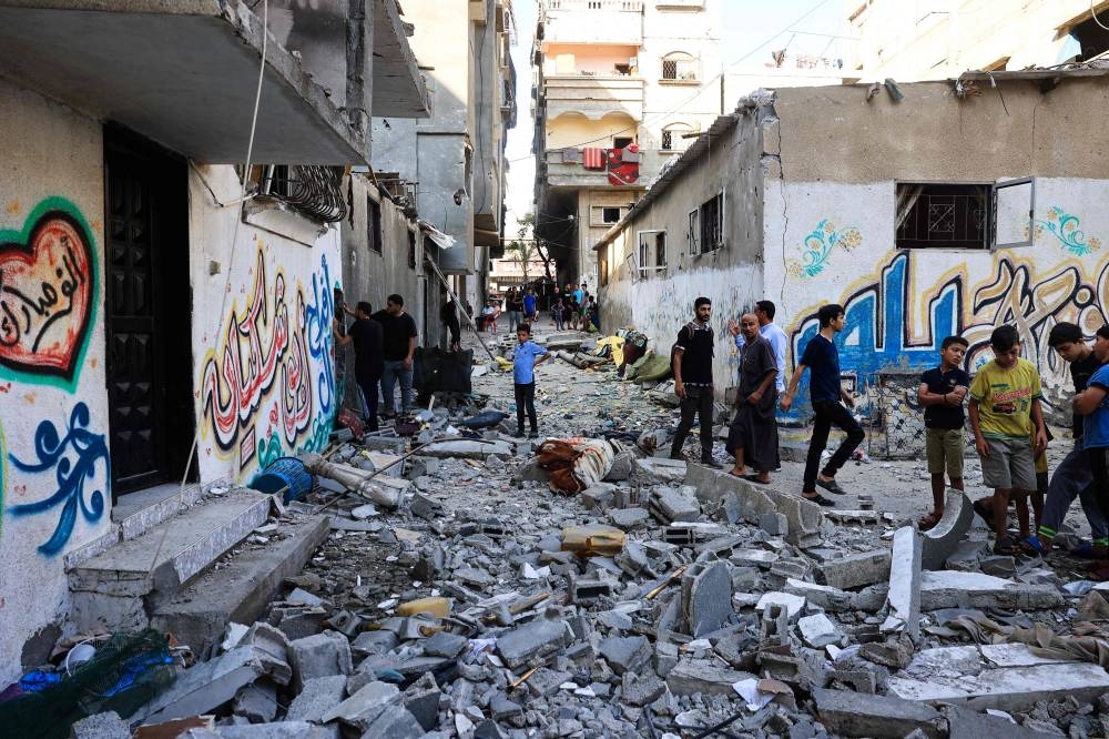 Palestinians asses the damage following an Israeli strike in the Nuseirat refugee camp in the central Gaza Strip on Saturday. AFP