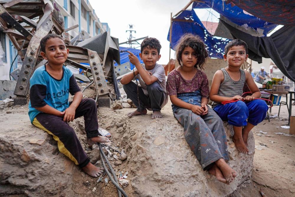 Palestinian children pose for a picture in Khan Yunis, on the southern Gaza Strip on Saturday. AFP