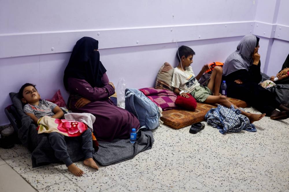 Palestinians are treated in the corridors at Nasser hospital, in Khan Younis, in the southern Gaza Strip, Monday.