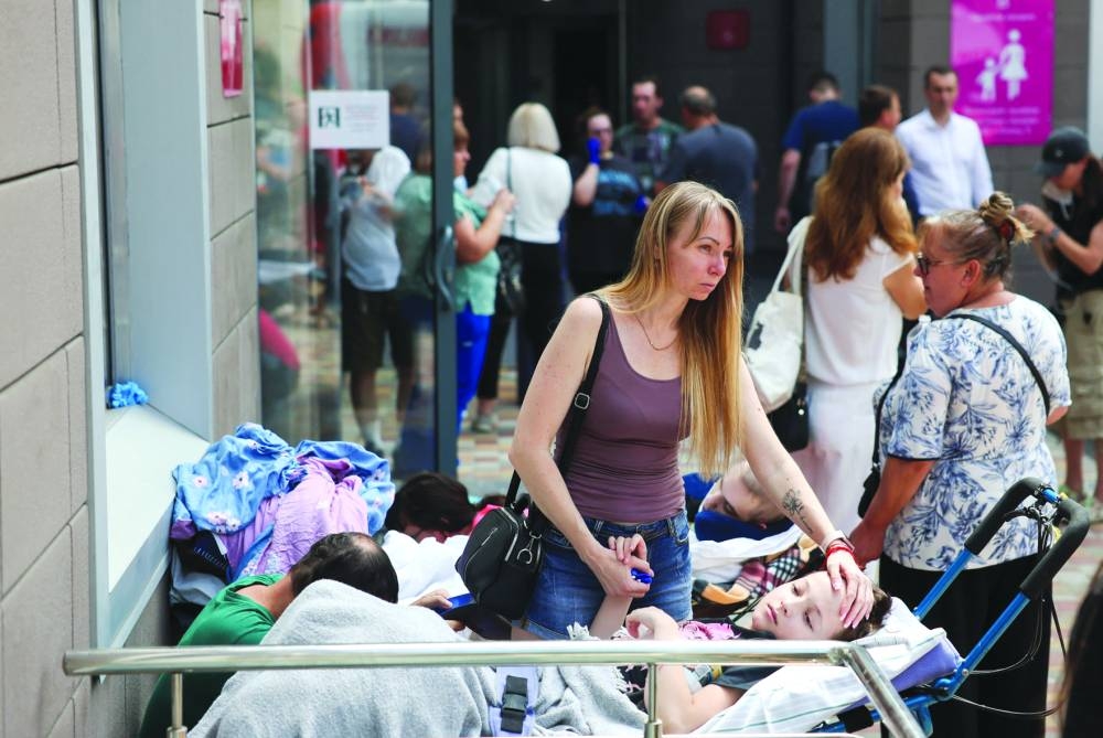 
A woman touches a patient near Ohmatdyt Children’s Hospital that was damaged during Russian missile strikes in Kyiv yesterday. (Reuters) 