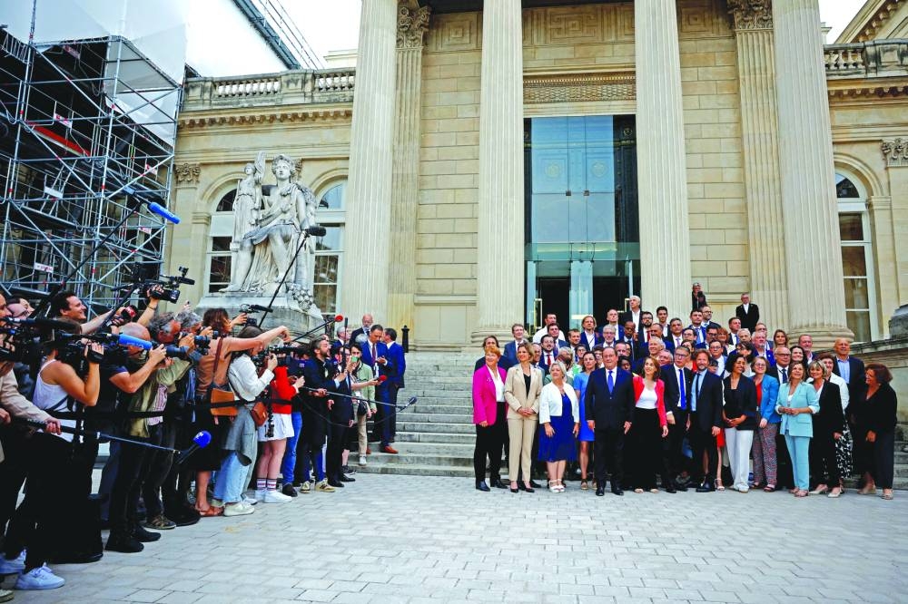 
Former French president Francois Hollande, Member of Parliament of the French Socialist Party and the left-wing parties alliance named “Nouveau Front Populaire”, poses for a family photo with Olivier Faure, First Secretary of the French Socialist Party, Boris Vallaud, and newly-elected PS lawmakers as they arrive at the National Assembly in Paris following the second round of the early parliamentary elections. (Reuters) 