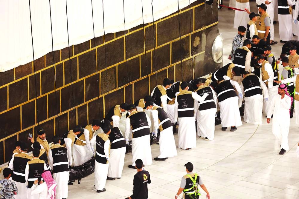 Saudi workers prepare to hang the new Kiswa.