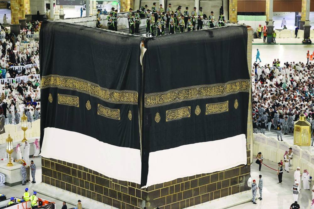 Saudi workers adjust the new Kiswa cover that adorns the Holy Ka'aba.