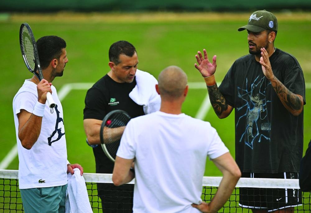 Serbia’s Novak Djokovic (left) talks with Australia’s Nick Kyrgios (right) as he takes part in a training session on the Aorangi practice courts on the 11th day of the 2024 Wimbledon Championships at the All England Lawn Tennis and Croquet Club in Wimbledon, southwest London, on Thursday. (AFP)